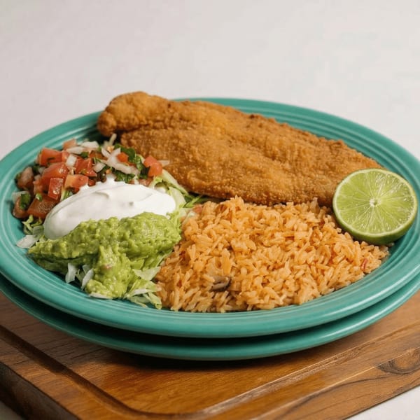 Amigos Mexican Restaurant's fried fish with rice, guacamole, pico de gallo, sour cream, and lime.