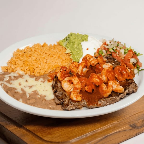 Amigos Mexican Restaurant's steak and shrimp dish with rice, refried beans, guacamole, sour cream, and pico de gallo.